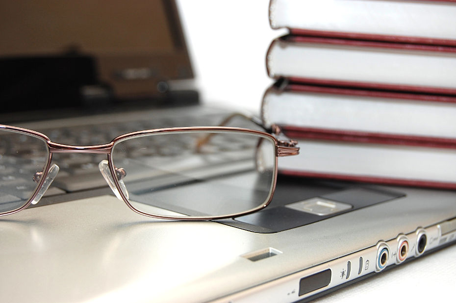 Brille und Bücher auf einem Laptop